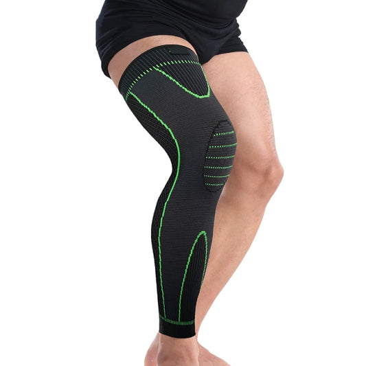 A black compression leg sleeve with green accents, designed for knee support and UV protection, being worn on a leg.