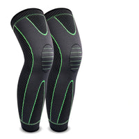 A pair of black compression leg sleeves with green accents designed for athletic activities, featuring an elastic band around the calf area.